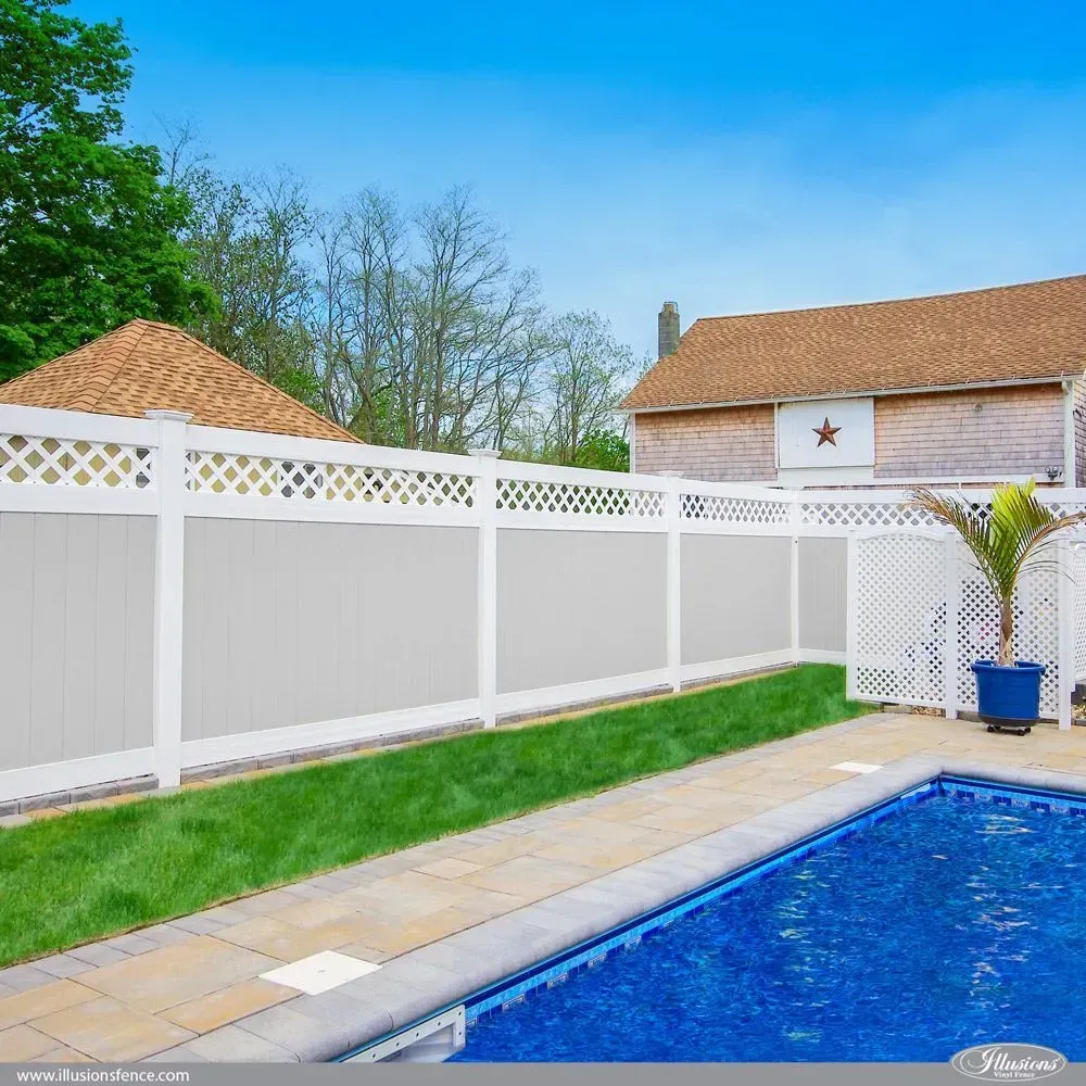 Gray vinyl privacy fence with a lush green backdrop.